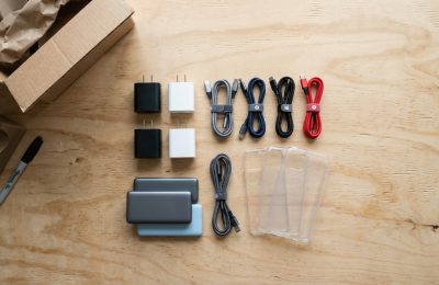 Cargadores, cables USB-C, fundas y baterías externas de marca ordenados en un mostrador de tienda.